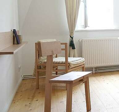 <p>Moderne Schlafzimmermöbel aus hellem Holz stehen in einem lichtdurchfluteten Zimmer. Cremefarbene Vorhänge und der Holzfußboden tragen zur Natürlichkeit bei.</p>