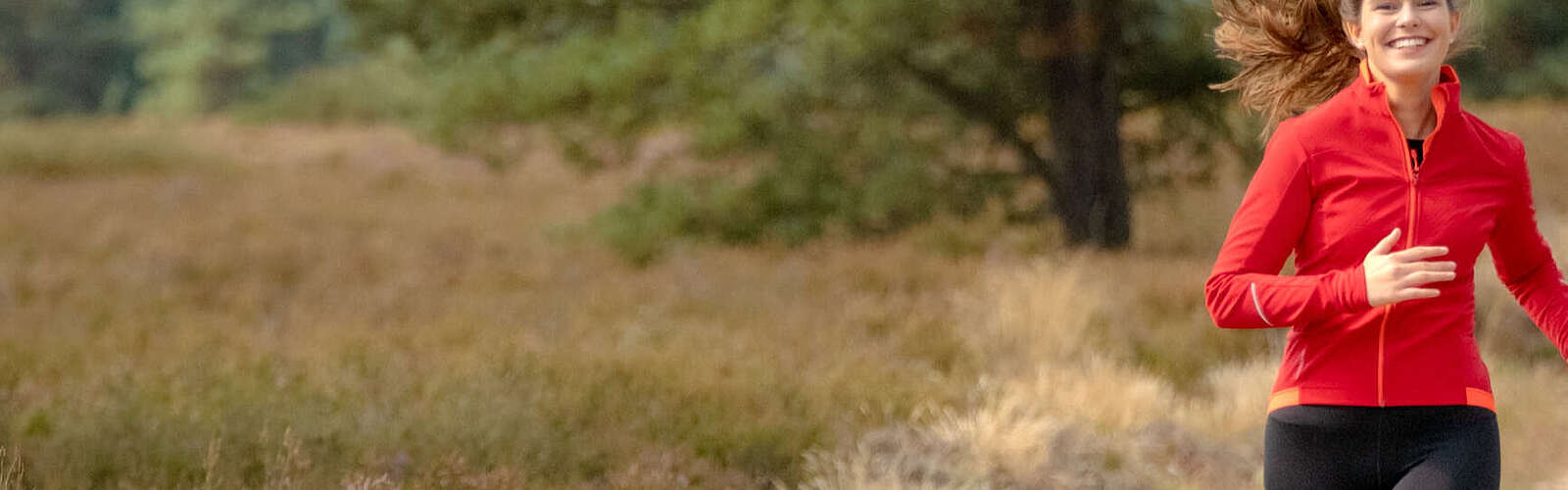 <p>Eine junge Frau joggt auf einem Sandweg durch die Kyritz-Ruppiner Heide</p>