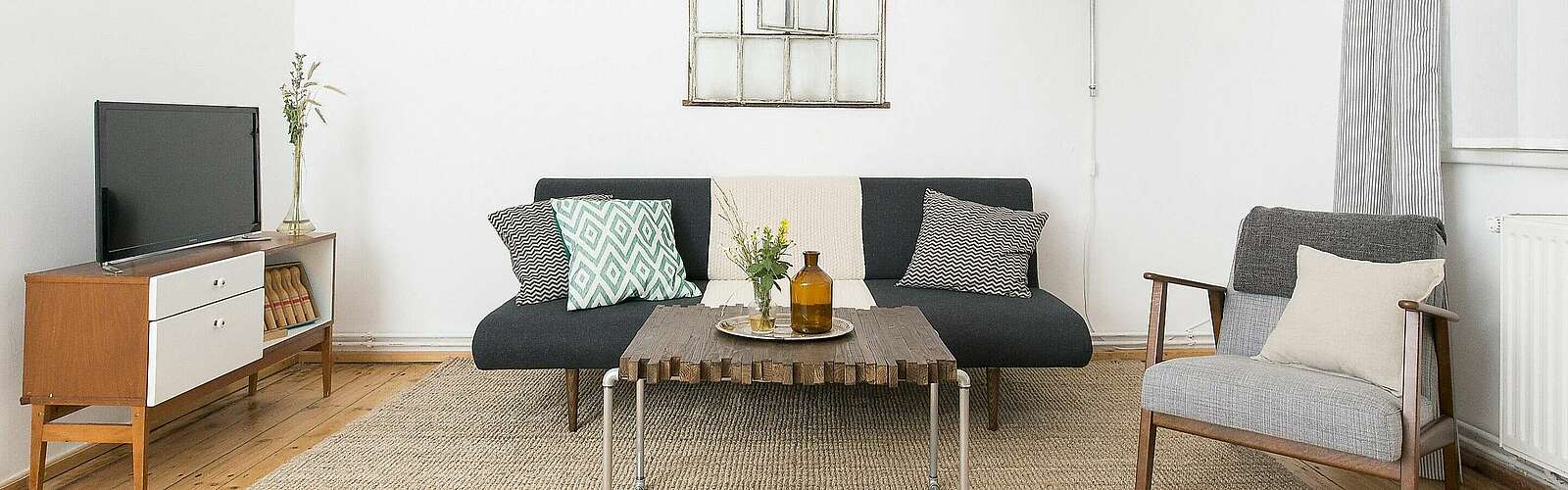 <p>Moderne Wohnzimmermöbel im Mid Century Style und hohe Decken strahlen Natürlichkeit und Komfort aus.</p>