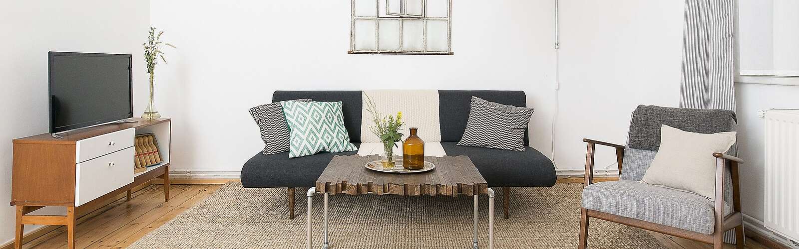 <p>Moderne Wohnzimmermöbel im Mid Century Style und hohe Decken strahlen Natürlichkeit und Komfort aus.</p>