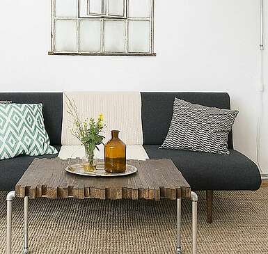 <p>Moderne Wohnzimmermöbel im Mid Century Style und hohe Decken strahlen Natürlichkeit und Komfort aus.</p>