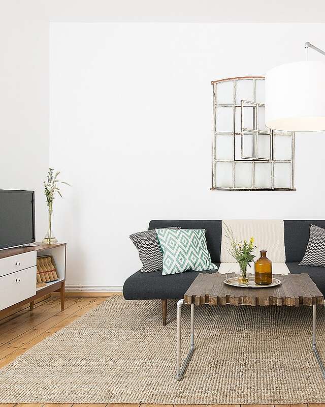 <p>Moderne Wohnzimmermöbel im Mid Century Style und hohe Decken strahlen Natürlichkeit und Komfort aus.</p>