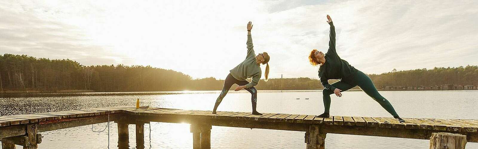 <p>Zwei Frauen machen Yoga am See</p>